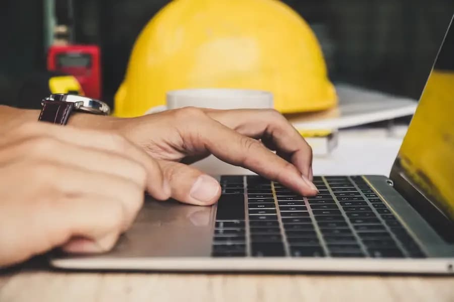 funcionário acessando notebook para baixar manual de plataforma elevatória no estado de São Paulo.