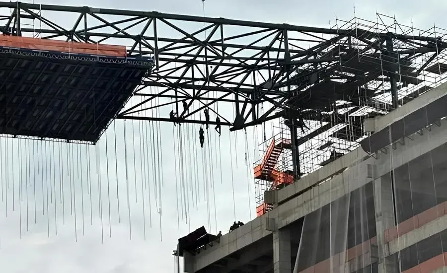 imagem mostrando 08 funcionários pendurados a uma altura de 140 metros devido desmoronamento de andaime.