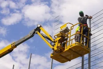 Trabalhador em plataforma elevatória tipo articulada utilizando ponto de ancoragem
